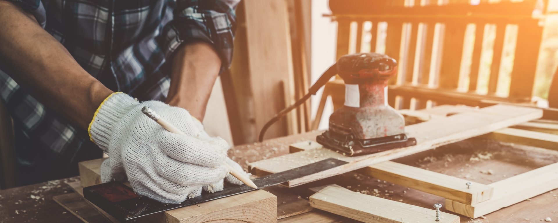 Master joiner hand-planing timber in workshop